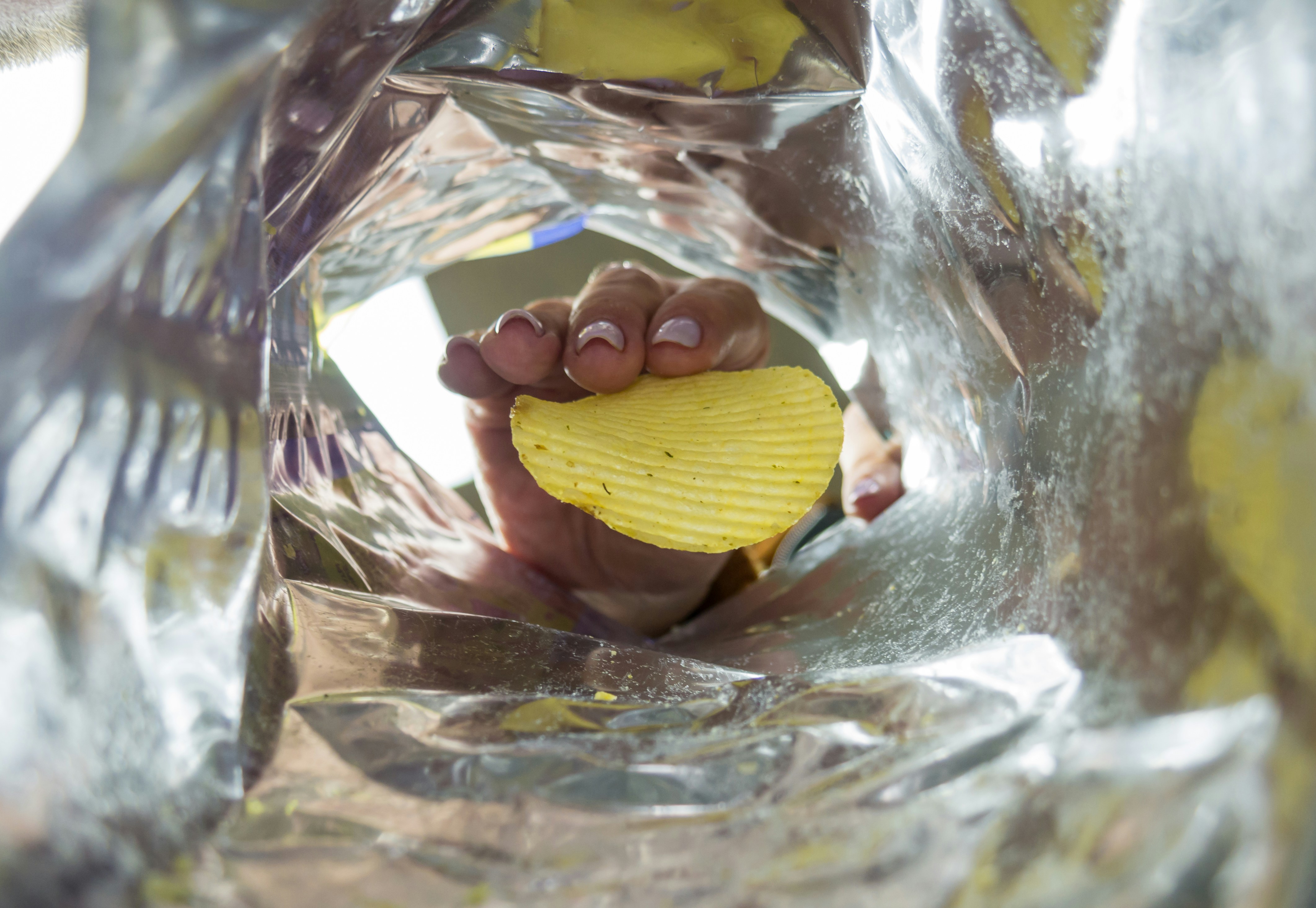 Woman takes crisps from packet